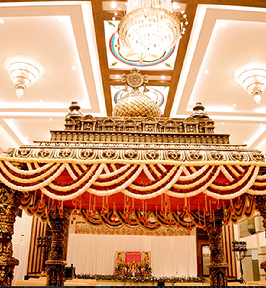 Grand traditional mandap with marigold drapes and chandeliers by Versato Ventures, Bengaluru
